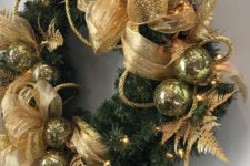 24 a lush and holiday Christmas wreath decorated with gold bows, tassels and ornaments
