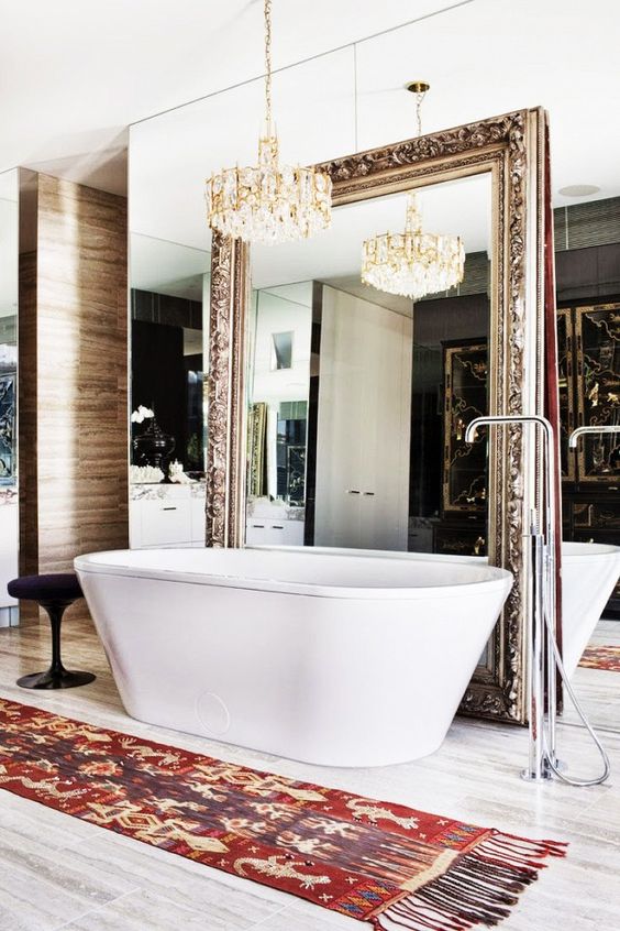 a mirror wall and an oversized refined vintage mirror over it to create a sophisticated space