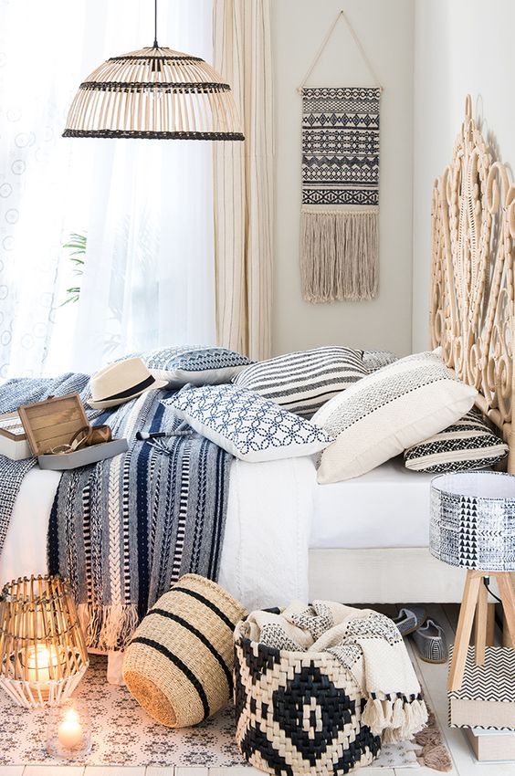 lots of printed textiles, wicker baskets, lamps, a headboard and a hanging make the bedroom Mediterranean at once