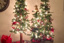 25 a trio of Christmas trees in galvanized buckets, with lights, red decor, stars and gifts all around