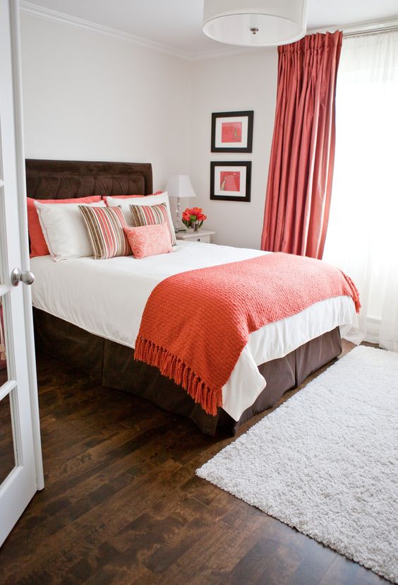 coral curtains, a coral throw and pillows add a trendy colorful touch to the bedroom and make it cheerful