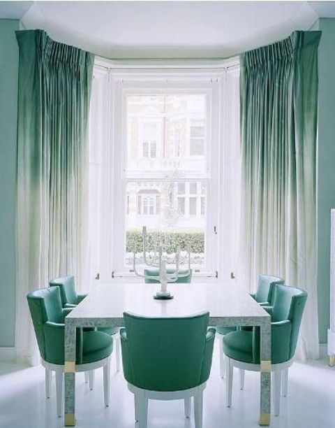 ombre green to white curtains and matching green chairs create a peaceful and welcoming dining room