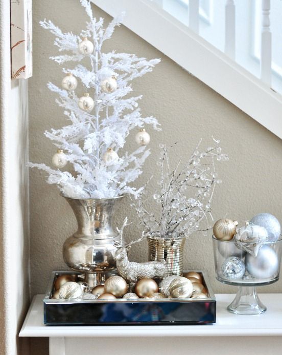 gold and silver ornaments can be displayed on white trees and branches, in bowls and jars for a frozen look