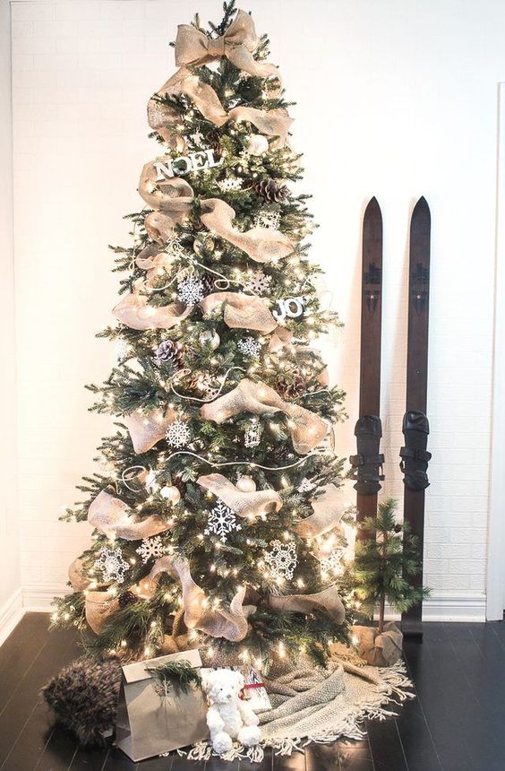 a cozy rustic Christmas tree decorated with snowflakes, pinecones, lights and burlap ribbons for a rustic feel