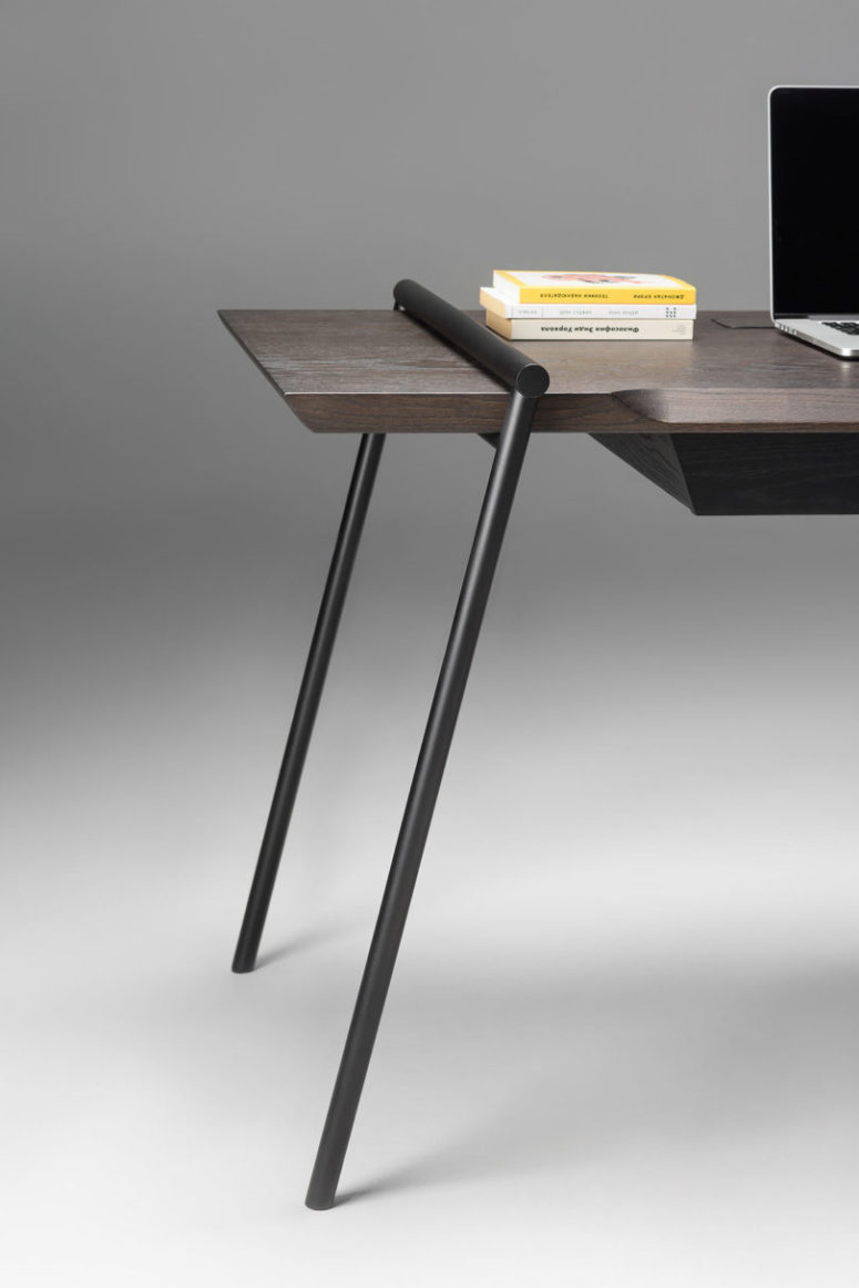 The desk is made of dark and stylish veneer, and there are matte black legs placed in a catchy way
