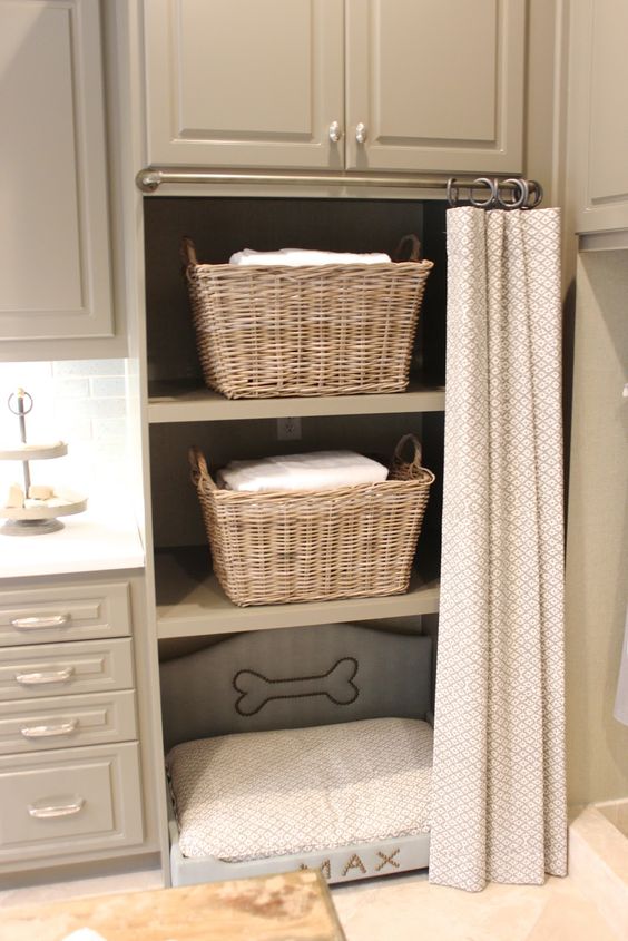 a laundry room with storage cabinets and an incorporated dog bed for your pet to relax while you are doing things