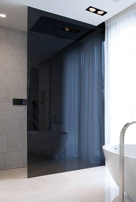 a minimalist bathroom with a smoked glass shower to separate the space gently and with an edgy feel