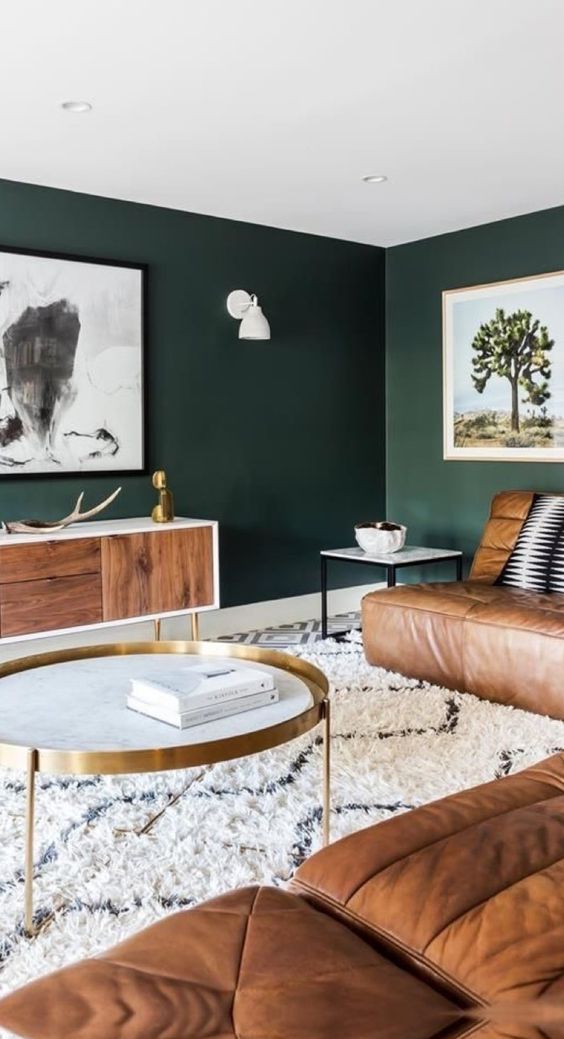 dark green walls contrast warm brown leather furniture and make the living room very relaxing