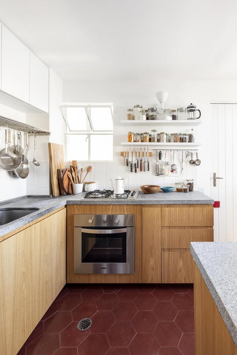 The kitchen is done with white and wooden cabinets, with concrete countertops and a white tile backsplash