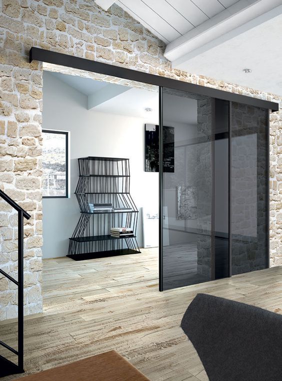 smoked glass sliding doors stand out in stone clad giving it a fresh and more modern look