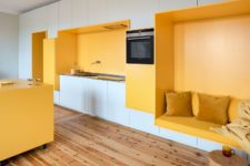 04 A yellow seat features an integrated kitchen unit and a comfy seat with pillows