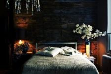 04 a moody bedroom with a weathered wooden wall and a boho bead chandelier is very welcoming