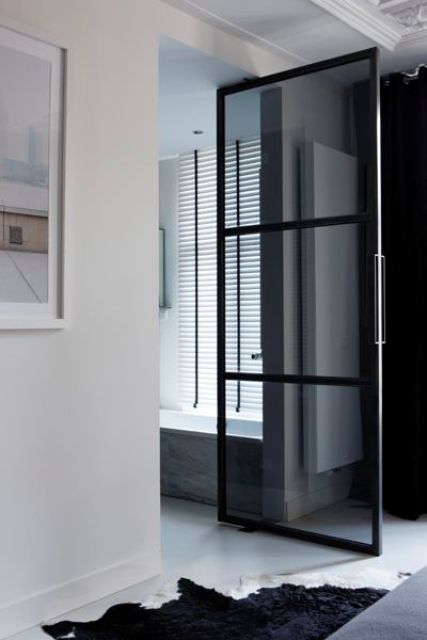a smoked glass door with window panes is a cool idea to separate your en-suite bathroom from the bedroom