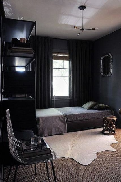 a comfy moody bedroom with layered rugs, thick curtains and dark bedding for winter