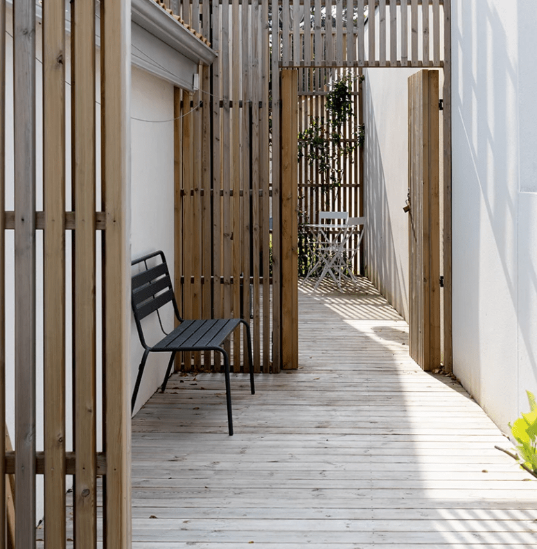There is an outdoor deck with some spaces divided with pine screens to unify the look from outdoors