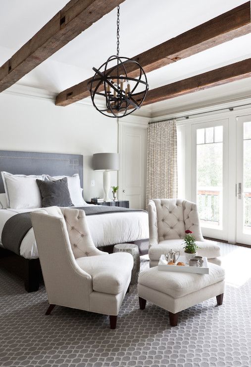 a couple of upholstered chairs and an ottoman by the foot of the bed is a simple idea