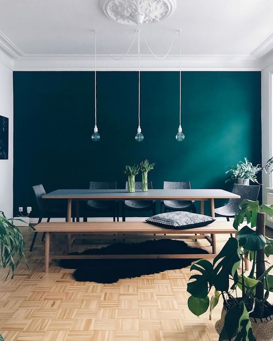 A dark green statement wall is a cool idea to update your dining room done in neutrals