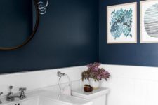 06 the bathroom features a contrasting look of a navy walls and white appliances and tiles