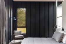 07 The bedroom also features black wood clad walls, windows fill the space with natural light