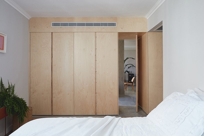 The master bedroom is very laconic and neutral, with a large plywood wardrobe and a comfy bed