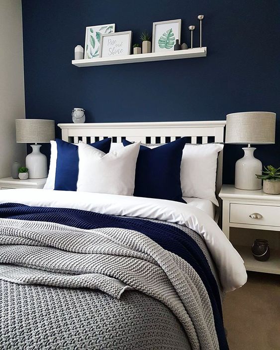 a cozy bedroom done in navy, white and greys looks contrasting, bold yet very inviting
