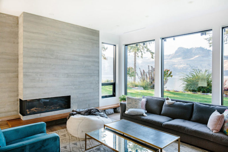 The living room is done with much glazing, a built-in fireplace and lots of colorful furniture