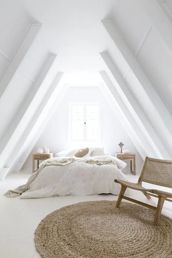 a totally white attic bedroom with wood and wicker touches that make it very cozy