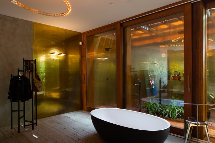 The bathroom features glazing, too, but the privacy is kept with an outdoor garden