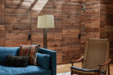 This space is done with weathered and rustic wood, there’s a cool woven chair and a blue sofa