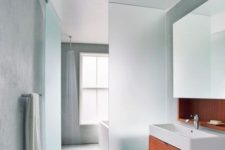 10 a plane of frosted glass separates the wet side of the bathroom, with the open shower, from the dry side