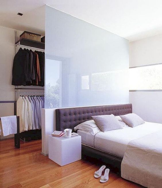 a half wall of frosted glass gently separates the closet from the bedroom, keeps it hidden but not too much