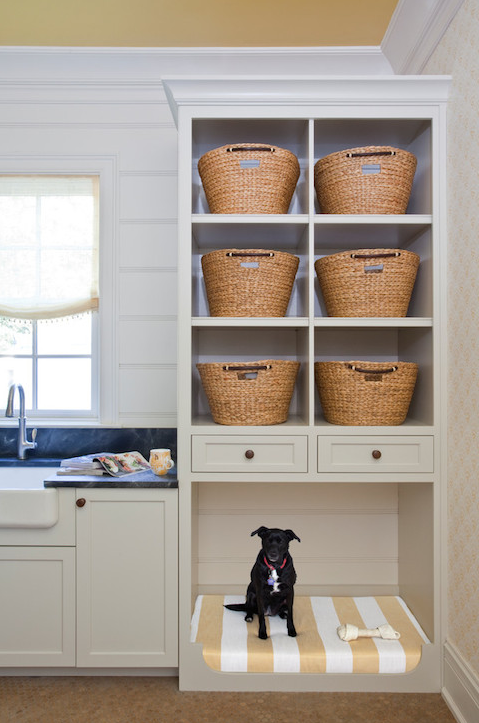 a laundry room with an open storage cabinet and a pet bed incorporated into its lower part