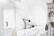 11 a totally white attic bedroom with a floating bed, much light and a single black rug for a contrast