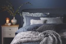11 a very cozy bedroom with a navy wall and navy and white bedding and blankets
