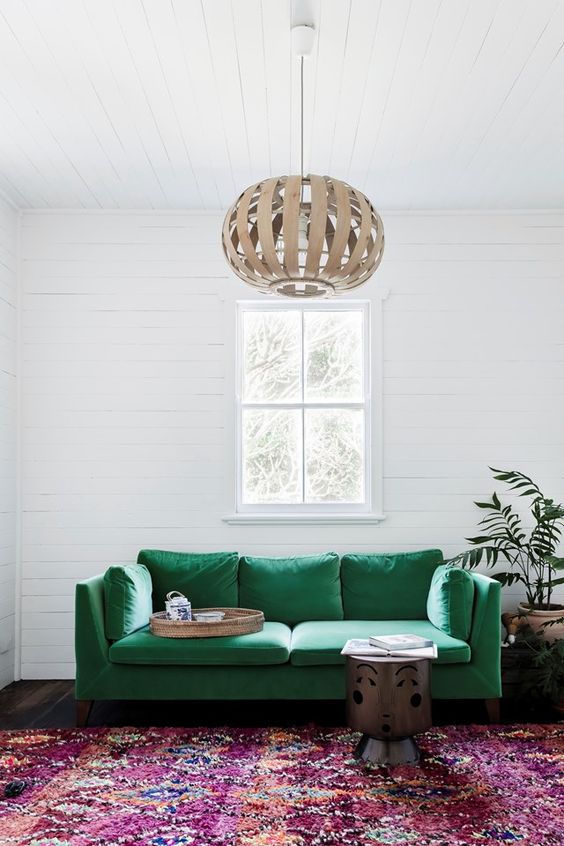 an emerald sofa will definitely make a bold statement in the living room and accent the space a lot