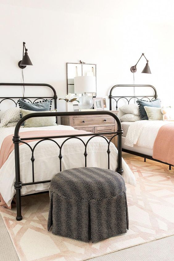 a farmhouse guest bedroom with two beds and touches of various muted colors