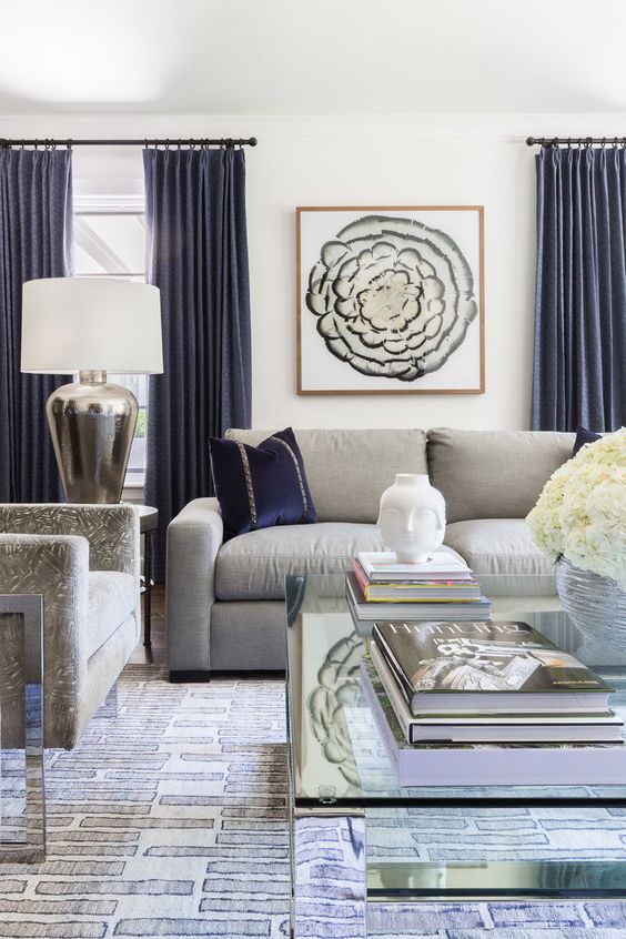 a stylish living room with grey furniture and navy pillows and curtains create a very chic and refined look