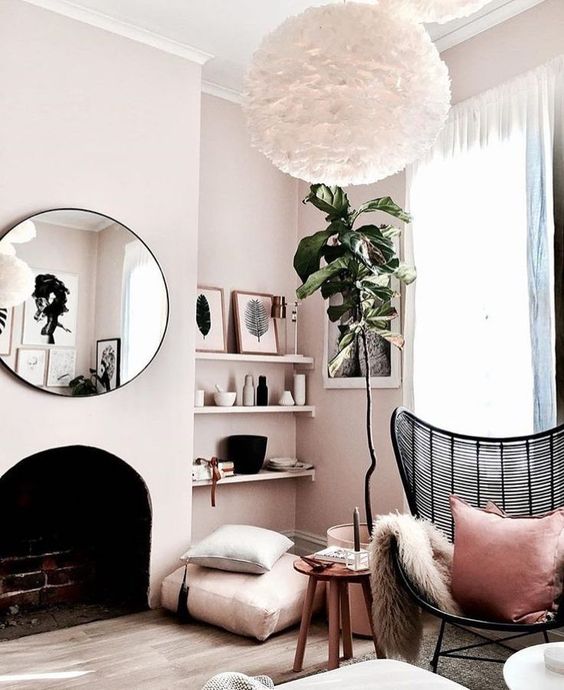 a cozy girlish bedroom with a brick clad built-in fireplace and a round mirror over it