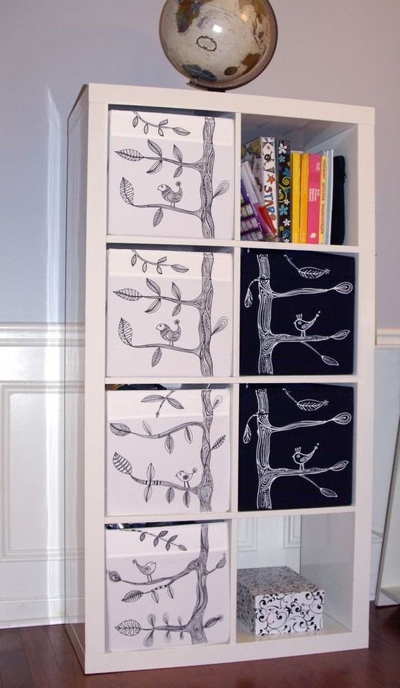 a white Expedit shelf with Drona storage boxes and cute EIVOR patterns of birds and trees