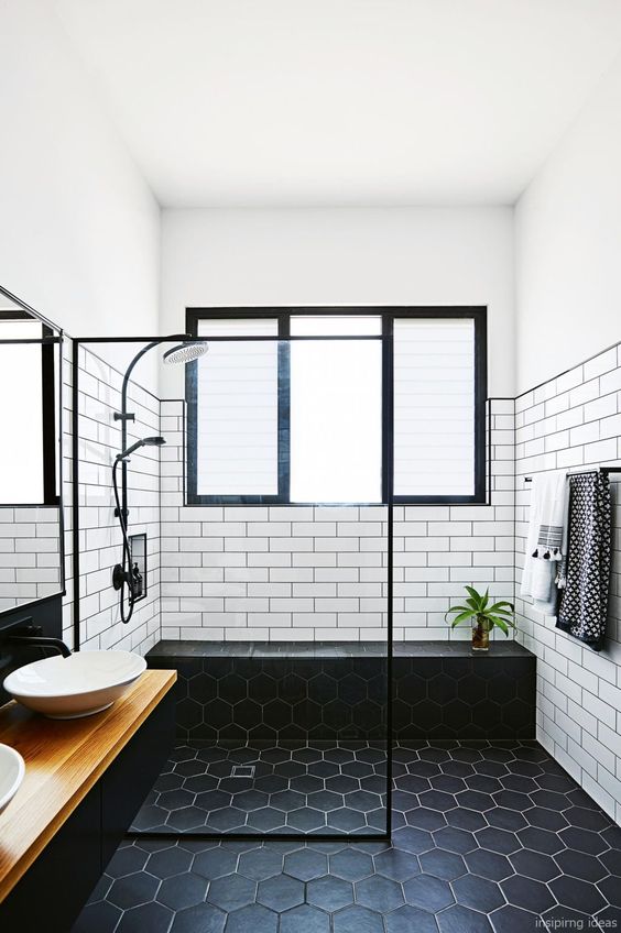 catchy black hexagon tiles on the floor and white tiles on the walls that help accent the floor