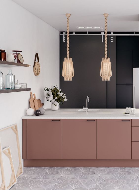 a feminine kitchen done in neutrals and accented with a black wall and dusty pink cabinets plus refined lamps