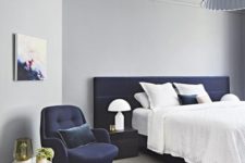 16 an airy bedroom in light grey with a navy upholstered bed and chair for a bold look