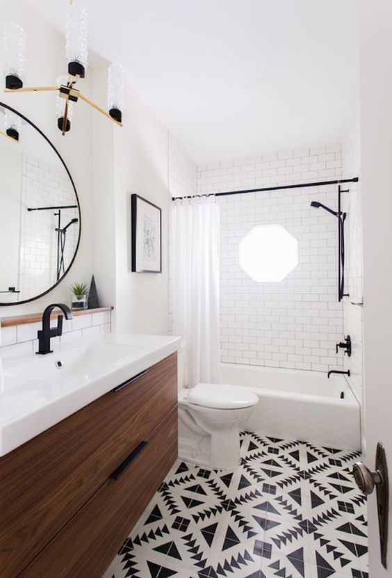 chic black and white mosaic tiles on the floor and white subway tiles with black grout on the walls for a bold look