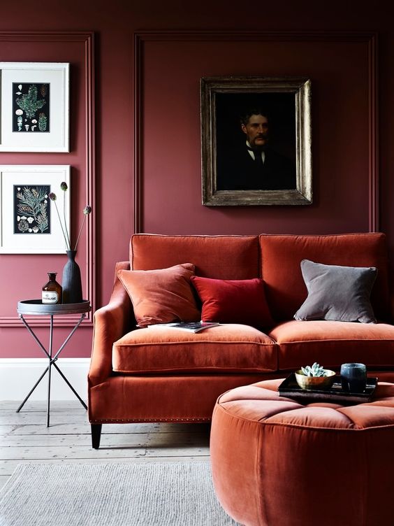 Create a color block effect with burgundy walls and rust colored velvet furniture