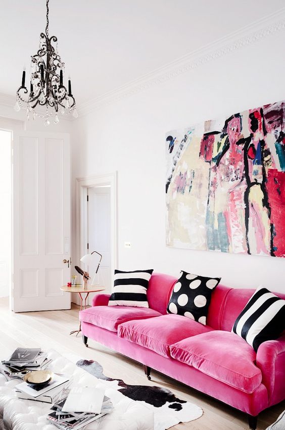 a pink velvet sofa makes a statement with texture and with bright color, black and white pillows create a contrast