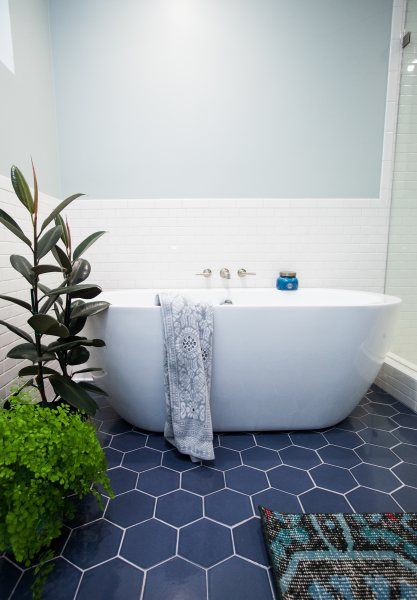 navy hex tiles on the floor ad white tiles on the walls create a bold and catchy combo for a modern bathroom