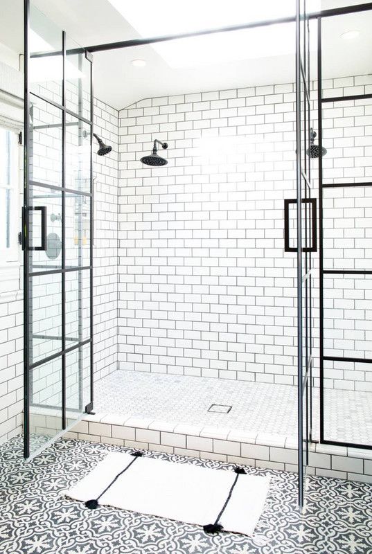 white subway tiles with black grout on the walls make up a cool combo with black and white mosaic tiles on the floor