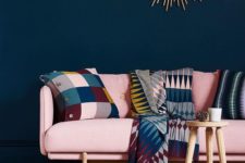 21 a sophisticated living room with a navy statement wall, a bold modern pink couch and colorful accessories