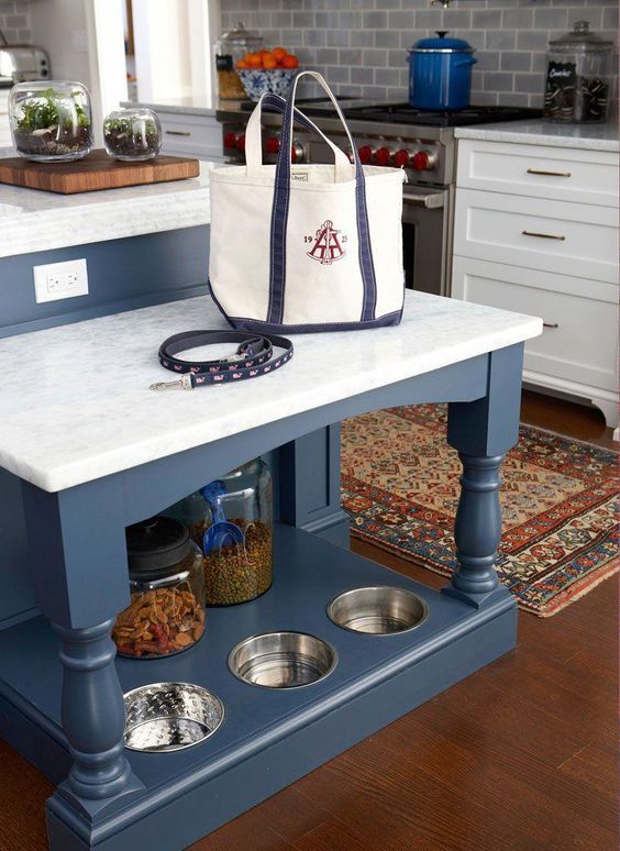 a kitchen island with an additional table and a dog feeding station and supplies organizer in its lower part