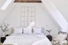 24 a very relaxing attic bedroom with a bed, bedside tables and a comfy chair by the window